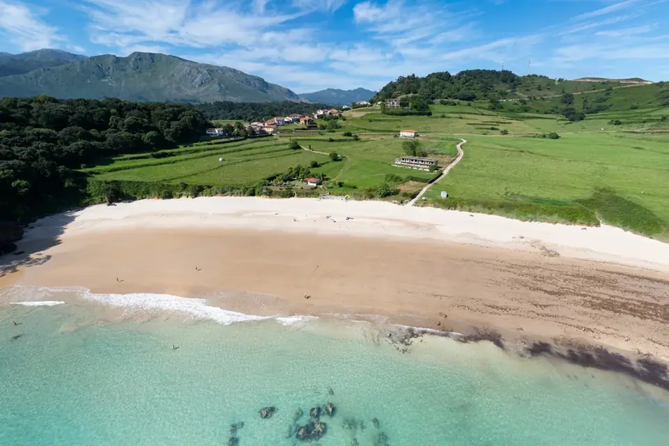 Playa de Toranda, arenal blanco y agua transparente junto a los prados de Niembro