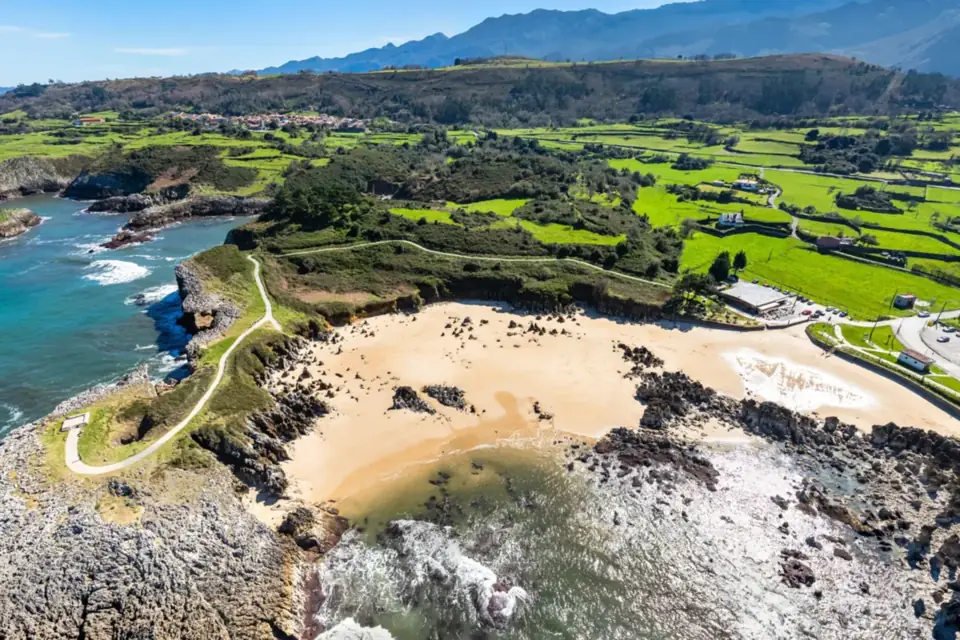 Playa de Toró con sus pináculos de roca en la arena y el paseo al mirador