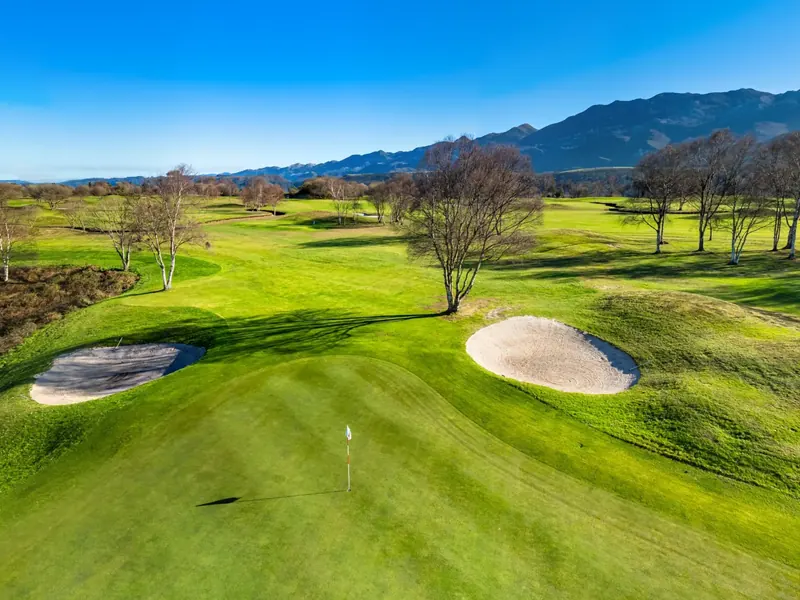 Green del hoyo 4 con su bandera y sus bunkers, fotografiado con dron
