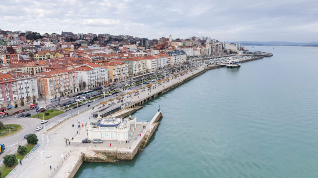 Atractiva vista de la ciudad junto al mar en La Coruña, Galicia, con edificios coloridos y paseo marítimo concurrido.